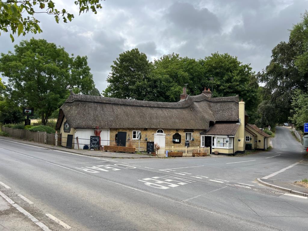 Lot: 39 - FREEHOLD PUBLIC HOUSE ON A TWO ACRE PLOT WITH CONSENT FOR 17 RESIDENTIAL DWELLINGS - View of traditional thatched roof pub on main road